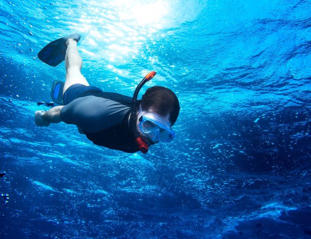 Young,Man,Diving,Snorkeling,Down,Into,The,Deep,Blue,Ocean